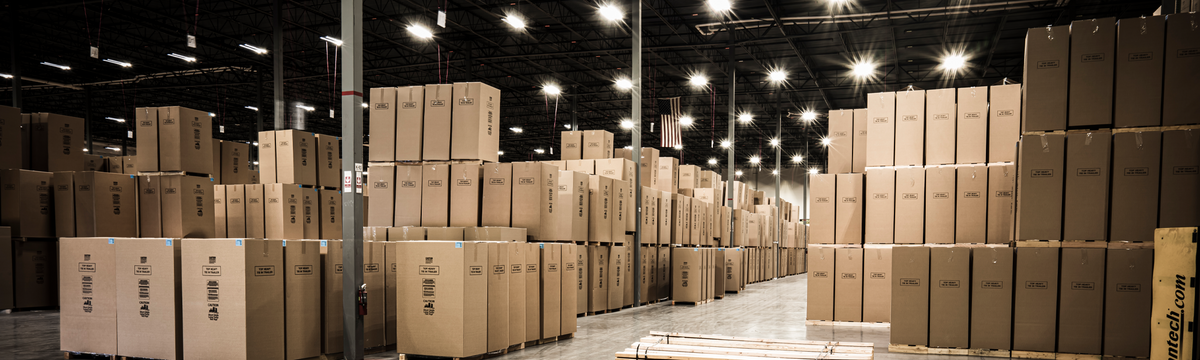 Stacks of boxed safes sit inside a well-lit warehouse.
